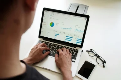 a person using a laptop with graph chart on screen a person using a laptop with graph chart on screen